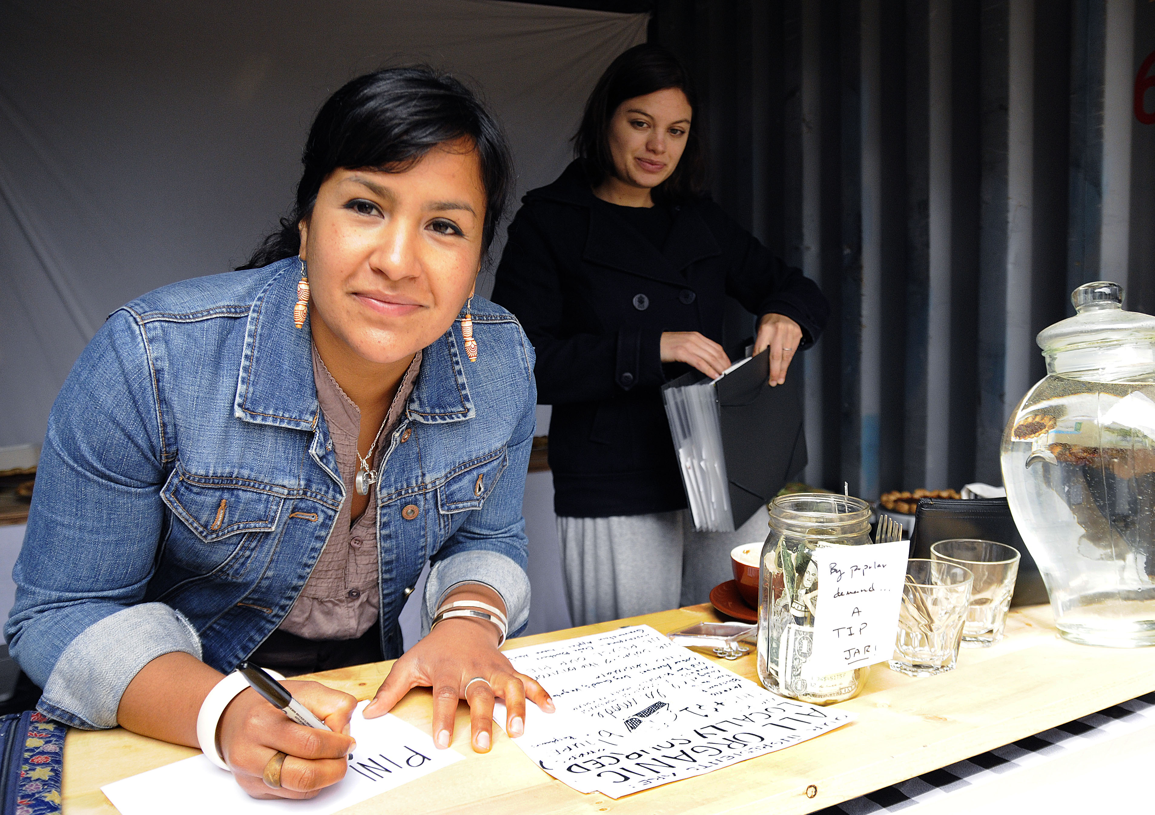 Two women selling Three Babes pies.