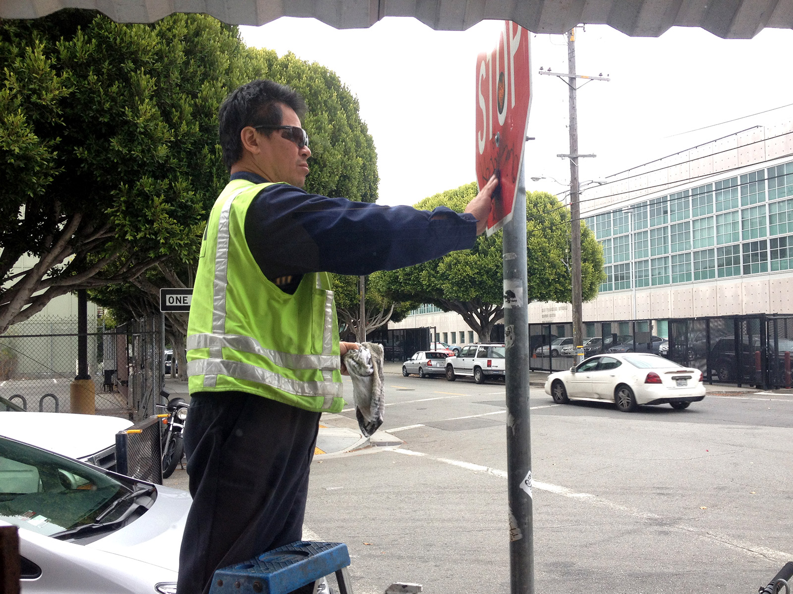Picture of a man cleaning a stop sign