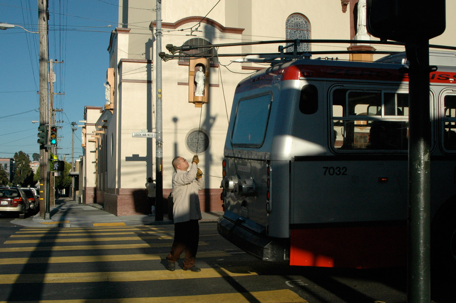 Picture shows a MUNI worker taking a bus off the wire.