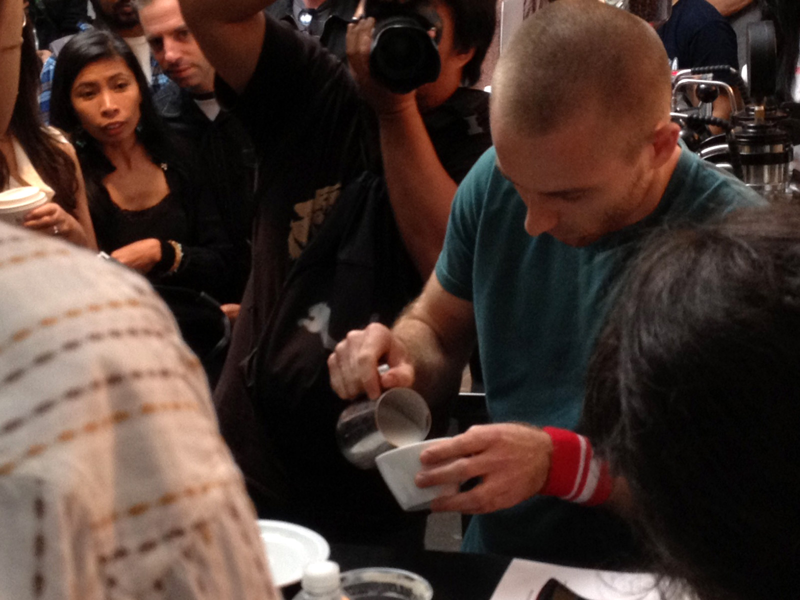 Image shows a man pouring latte art