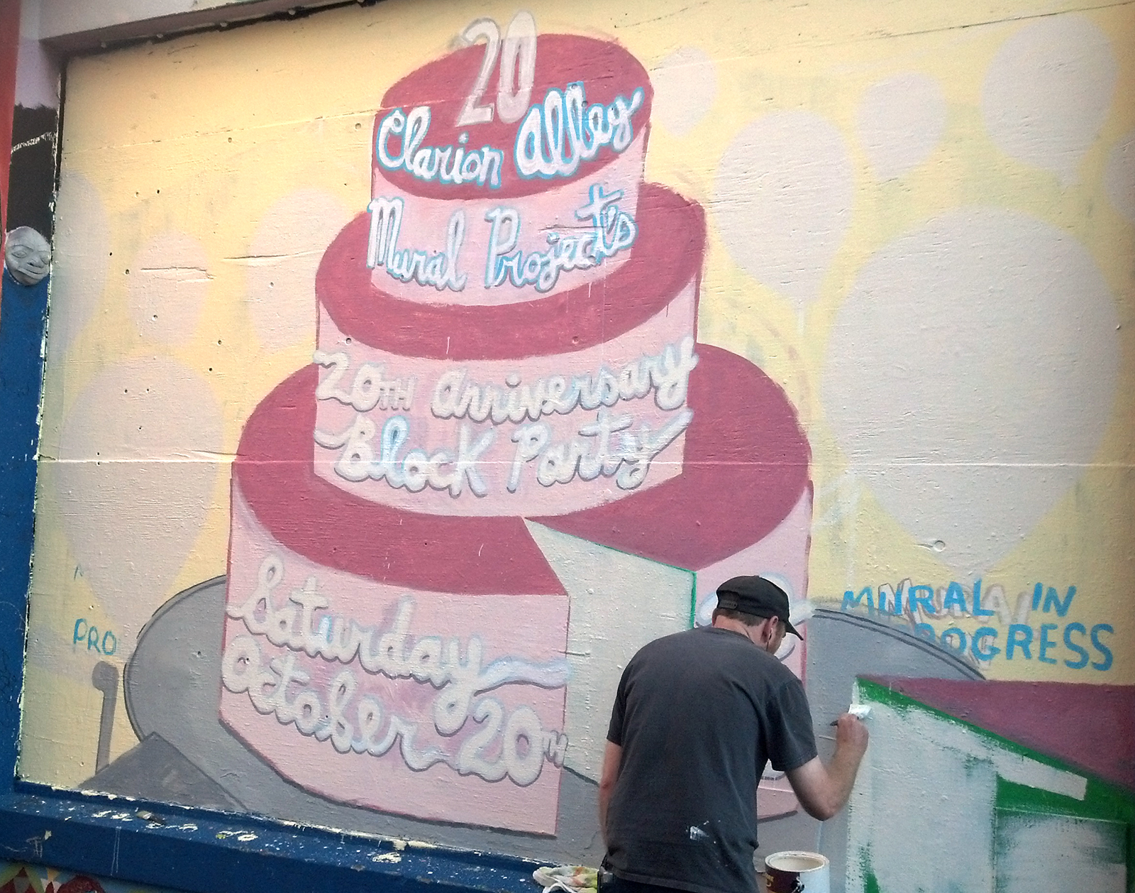 An artist paints a wall on Clarion Alley.