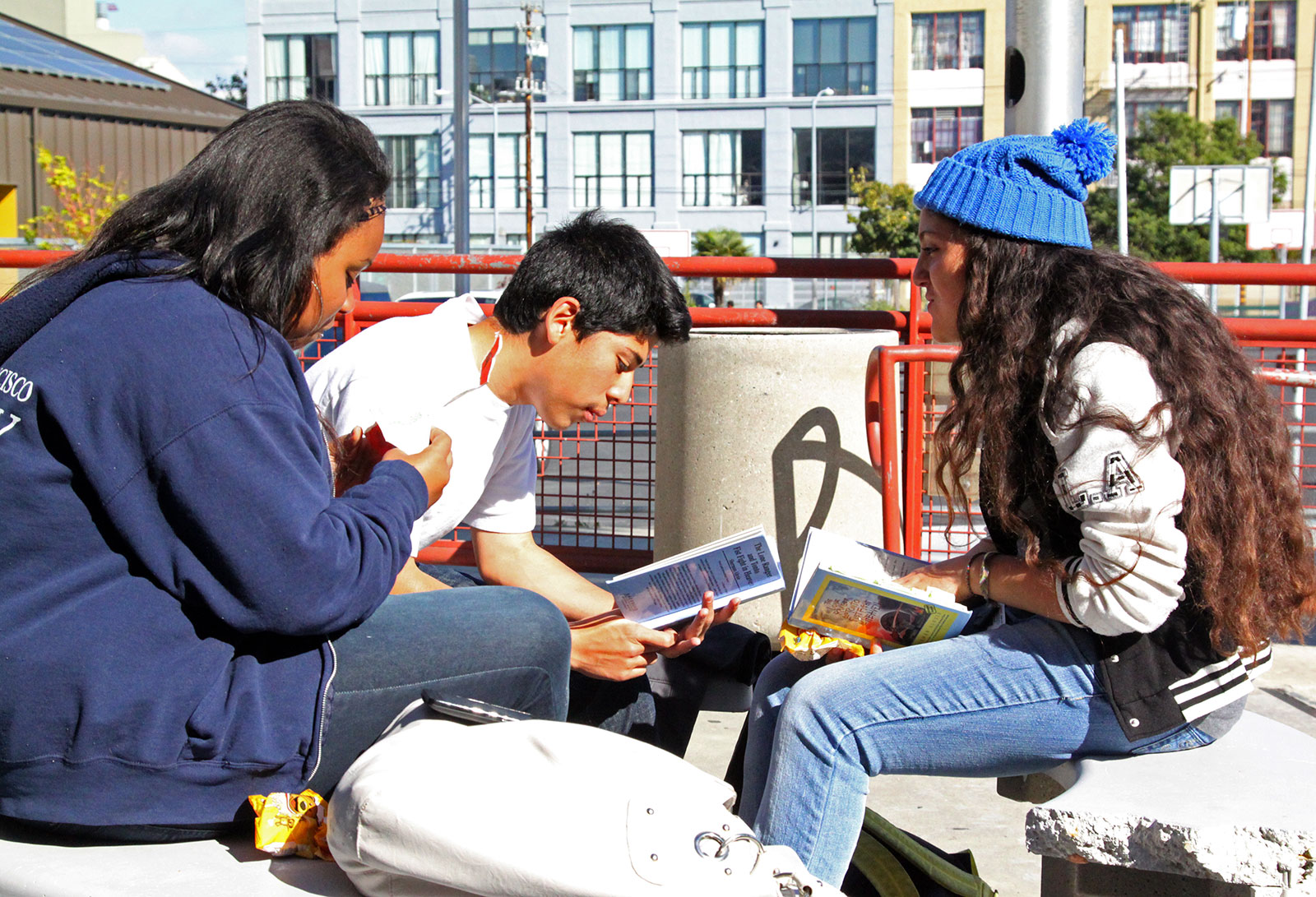 Students discussing a book outside