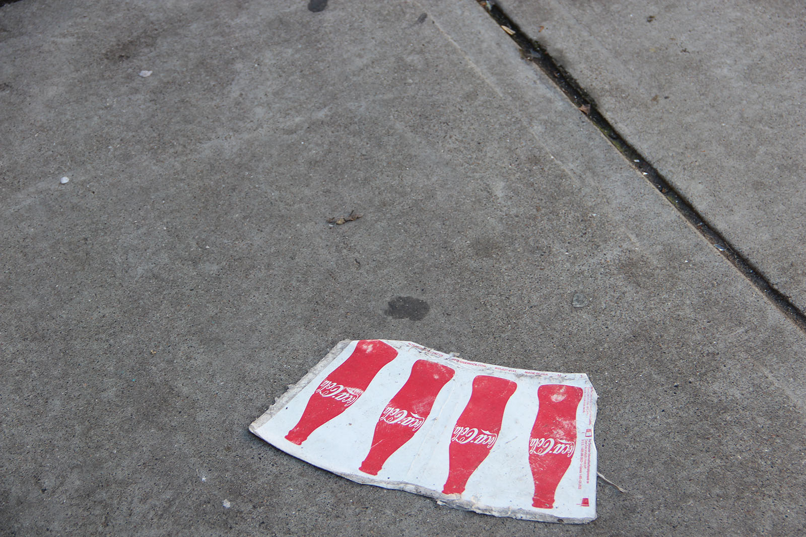 a paper coke cup has been flattened out on all sides