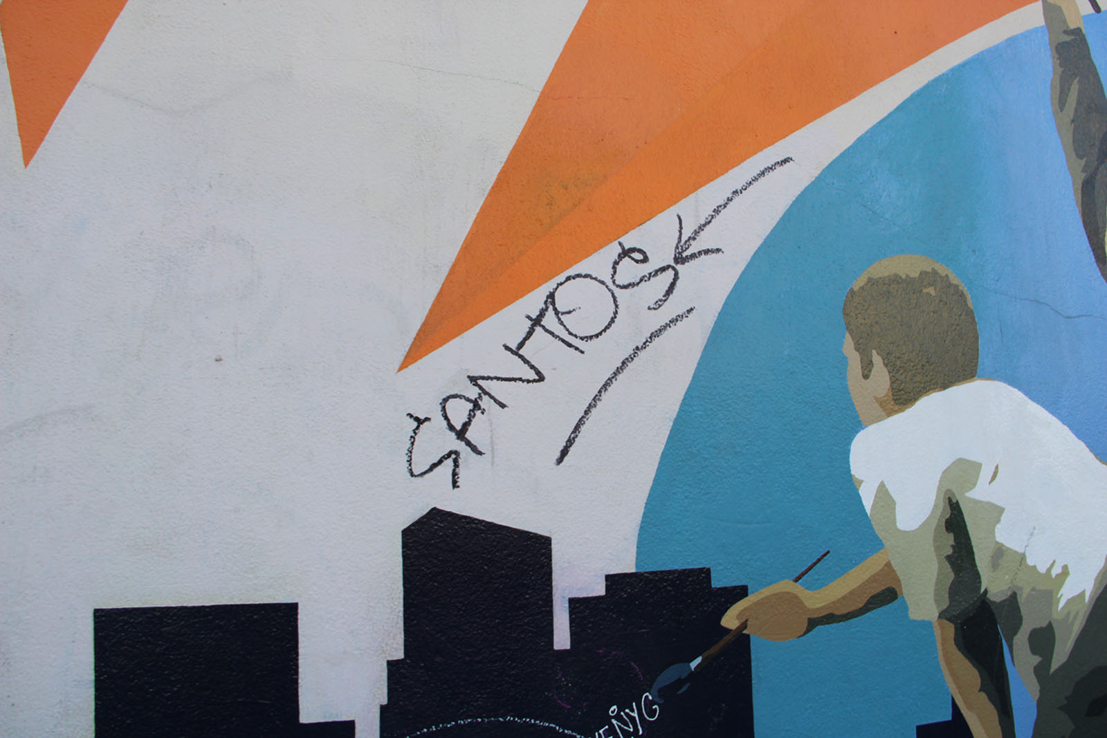 a mural of a boy painting with the graffitied word, "santos" above