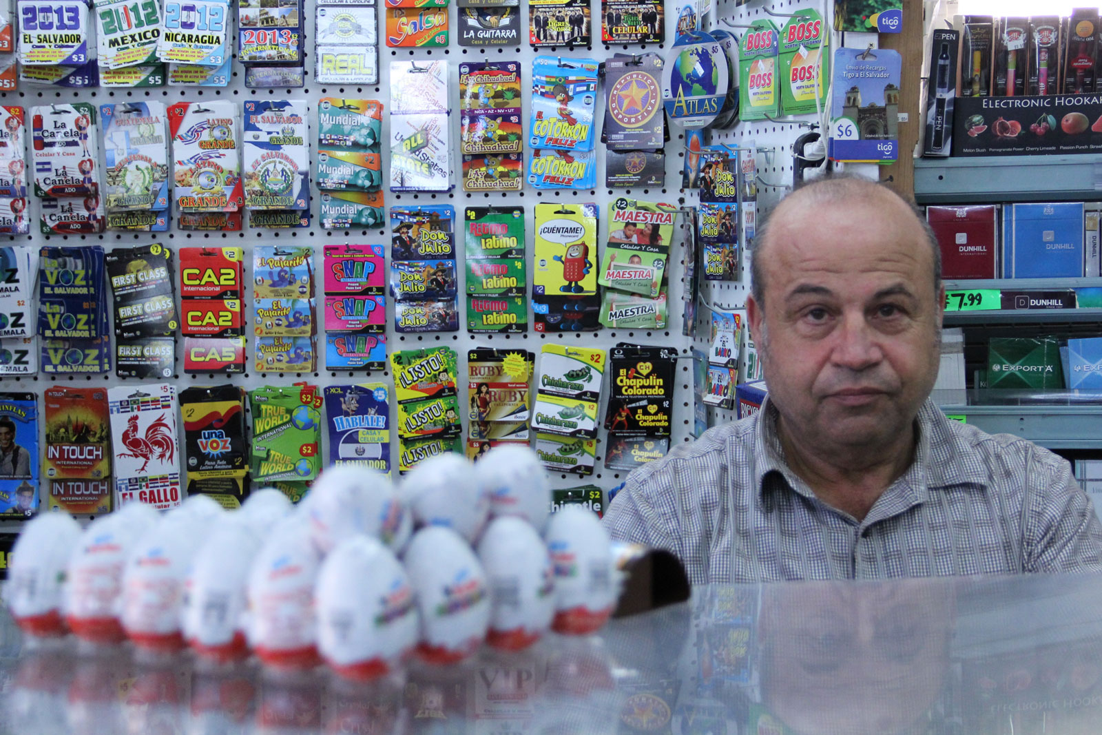 A man standing behind a liquor store counter.