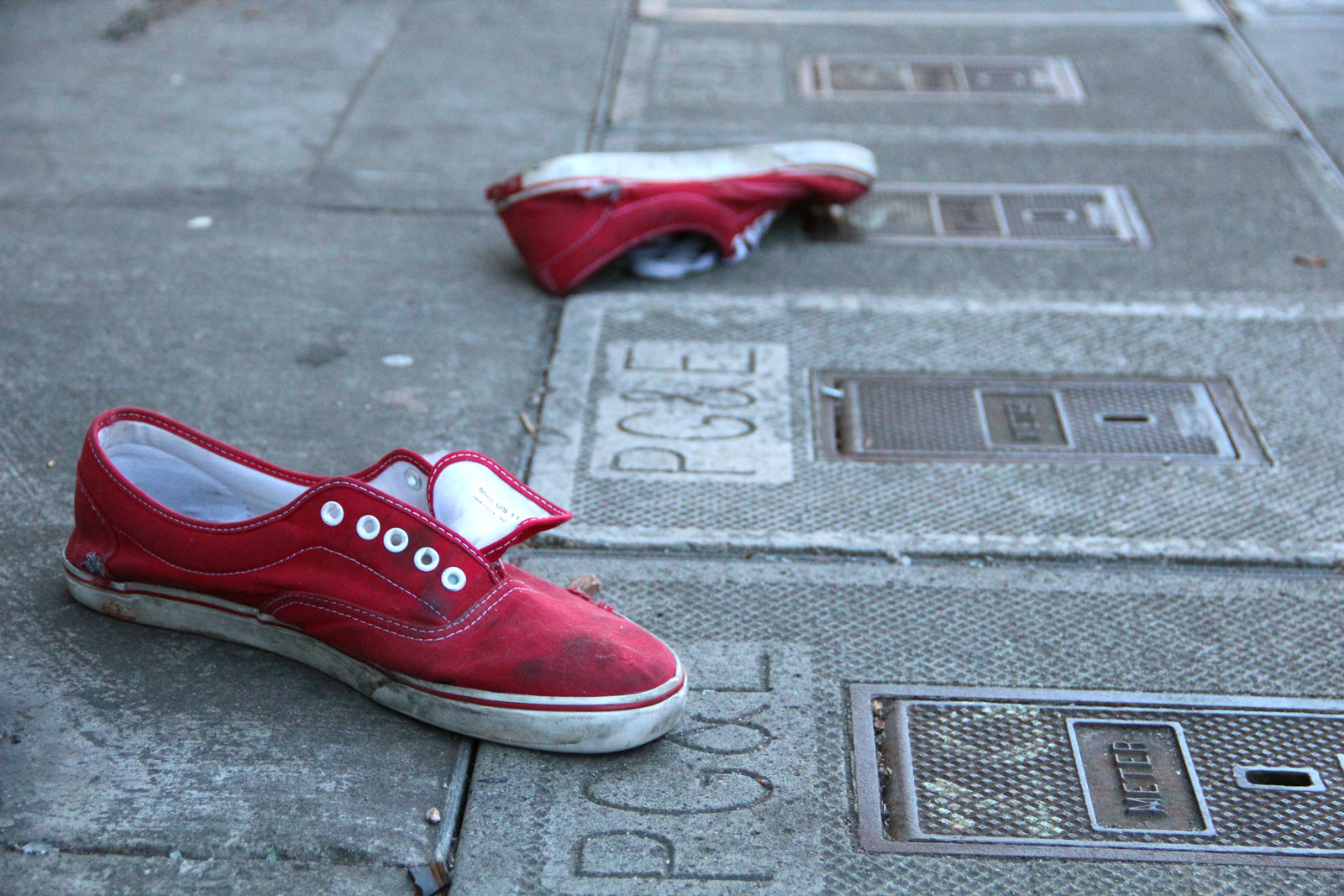 A pair of shoes on the sidewalk.