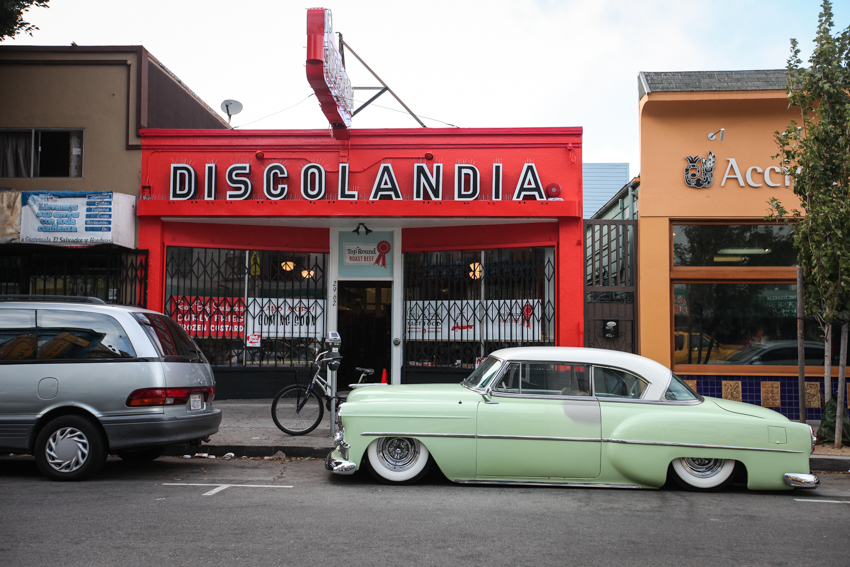 An old classic vintage car parks in front of Discolandia building