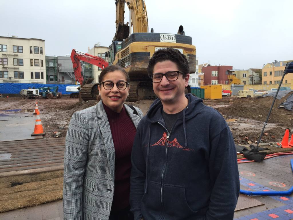 The two leaders of Mission Housing stand in front of a construction site of a new affordable housing project.