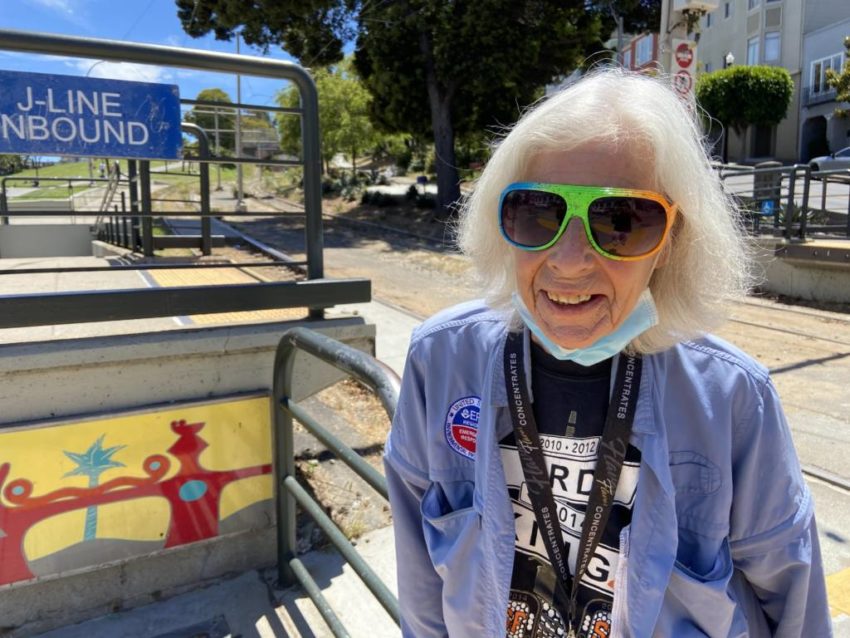 An older woman at a Muni stop