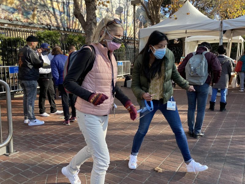 Two doctors with masks who appear to be running.