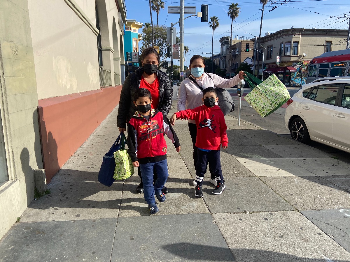 FIRST DAY OF SCHOOL, SAN FRANCISCO: Adriana Miranda (left), and her sister Claudia Miranda (right) walk their sons Cesar and Sebastian, both 5, to kindergarten at Zaida T. Rodriguez Early Education School. The sisters say they are excited to have their children back in school. Mission schools open first day during the pandemic. Image shows parents bringing their children back to school. Photo by Clara-Sophia Daly.