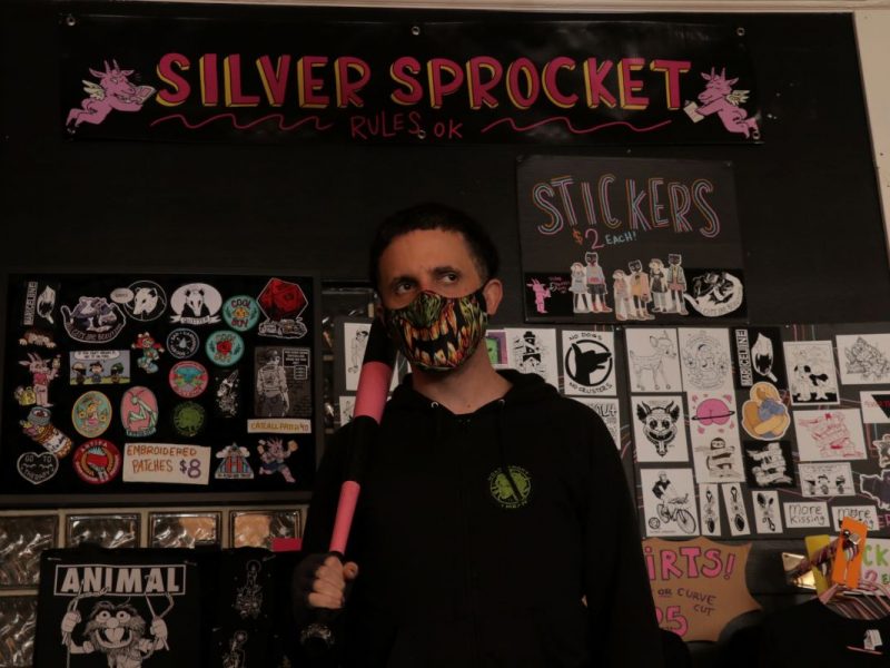 Avi Ehrlich stands with a striped pink baseball bat within his store on Valencia Street.