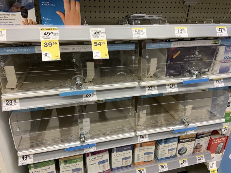 empty shelves with price tags for different brands of at home covid tests