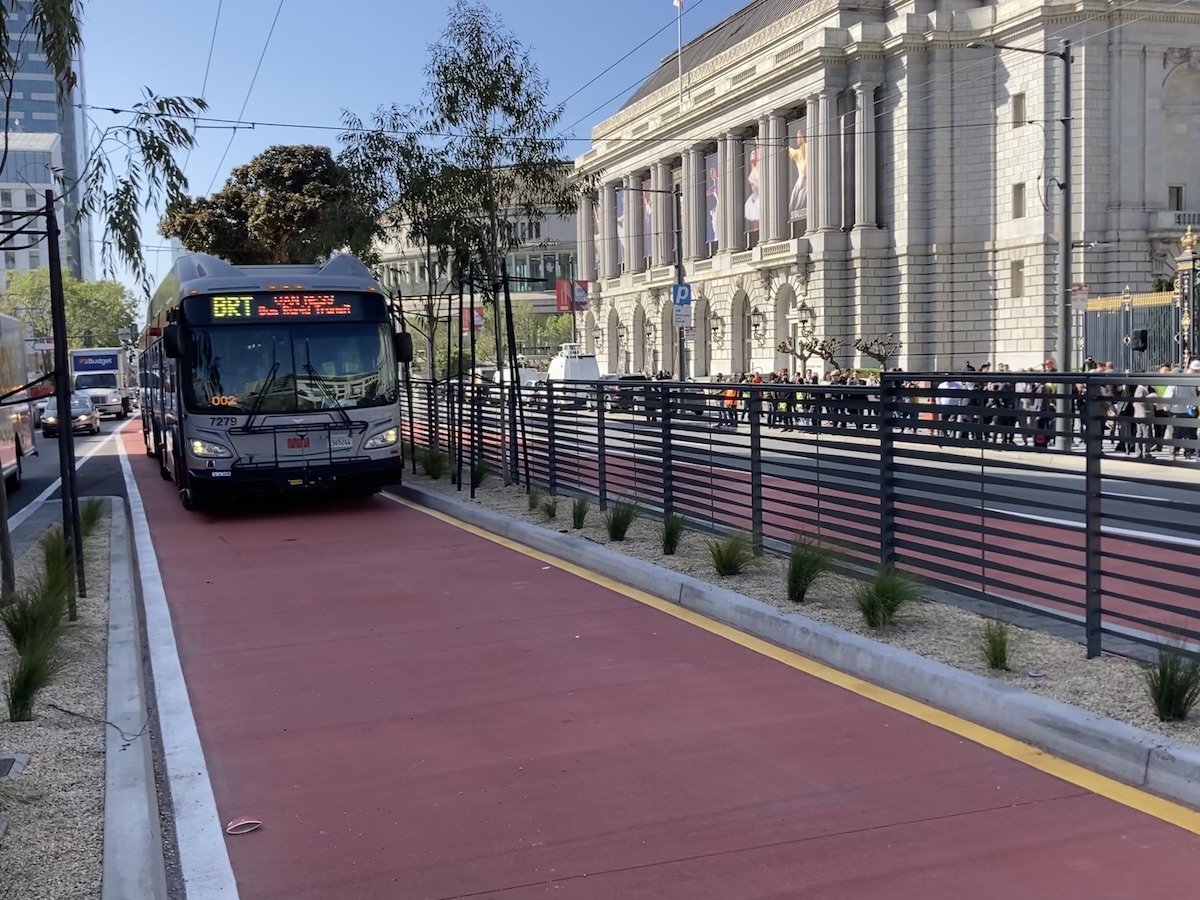 A "BRT" bus pulls up on a painted red lane