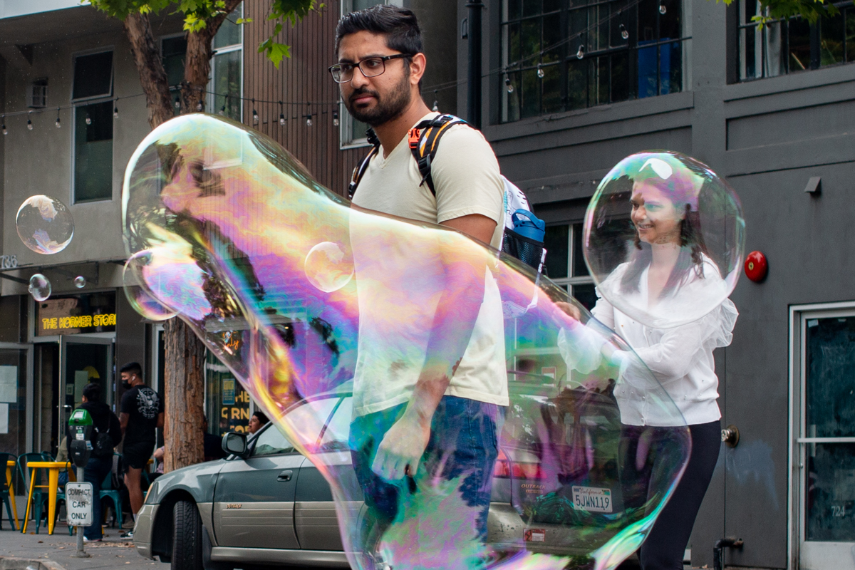 two people playing with air bubbles on Valencia Street