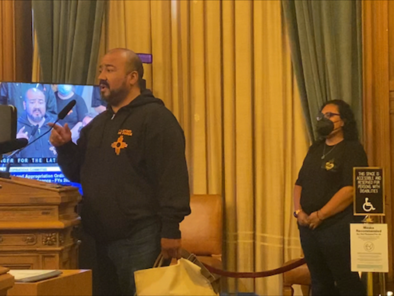 a man speaking into a microphone at the legislative chamber