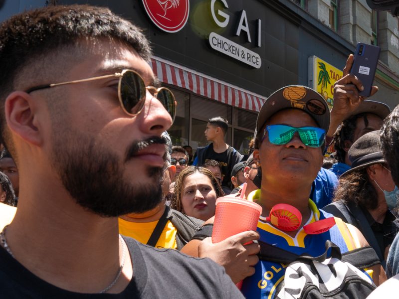 A crowd of Warriors fans look at the parade.
