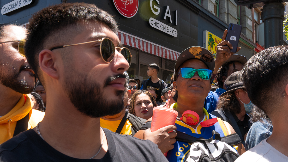 A crowd of Warriors fans look at the parade.