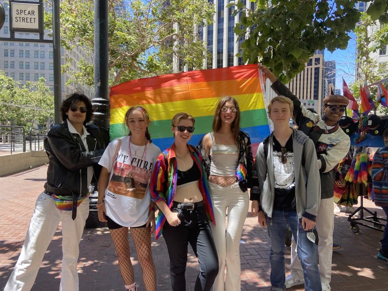 18 and 19-year-olds pose with a Pride Flag at the Pride parade