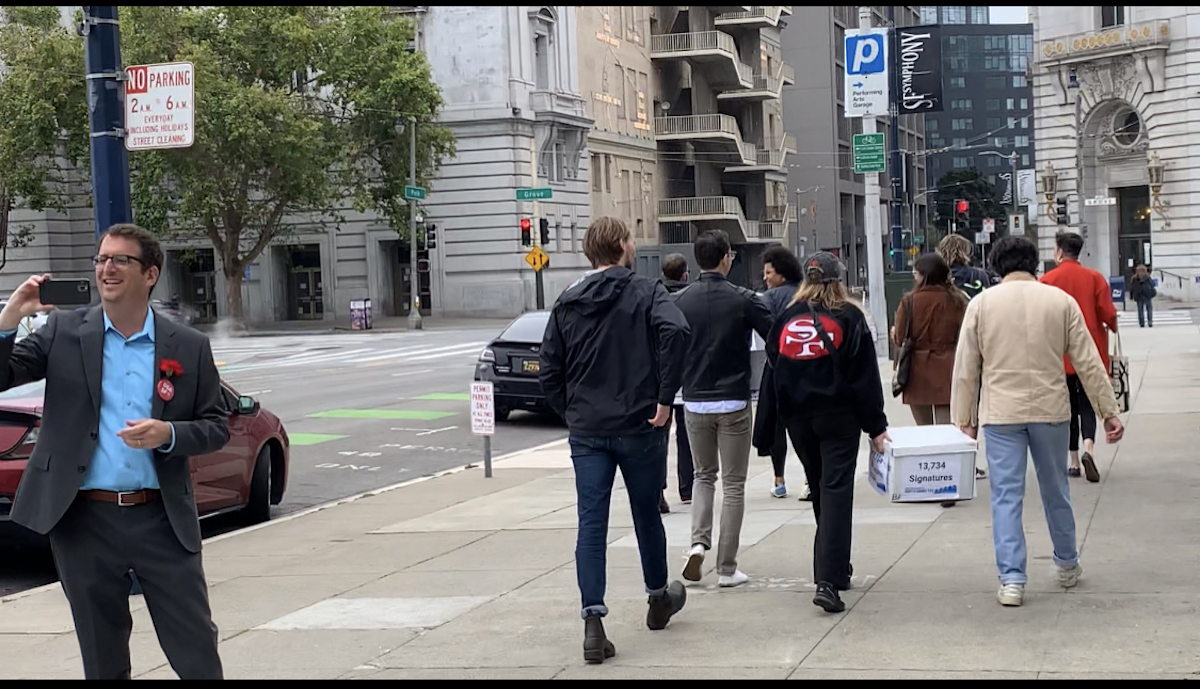 Dean Preston admires volunteers dropping off vacancy tax signatures.