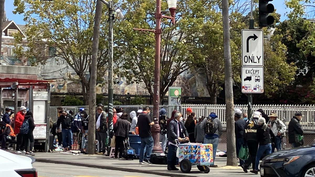 A mass of people and vendors line up at the Northeast 24th and Mission BART Plaza
