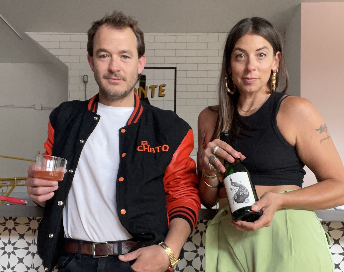 A man holding a glass of wine and a woman holding a bottle