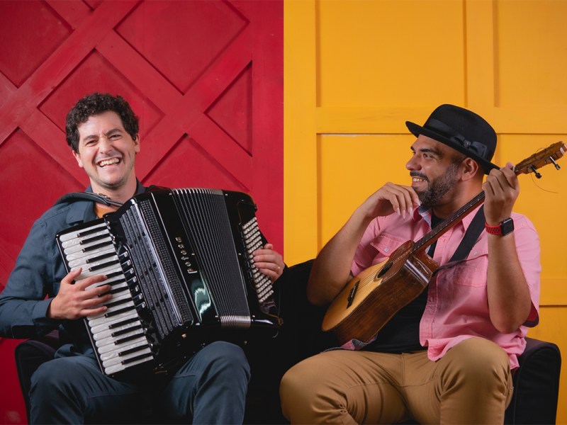 Sam Reider with an accordian and Jorge Glem with guitar