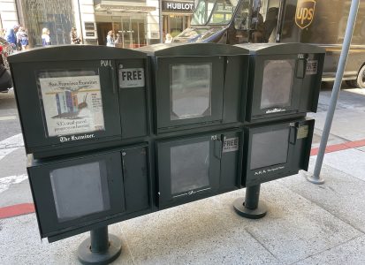 Photo of three news racks.
