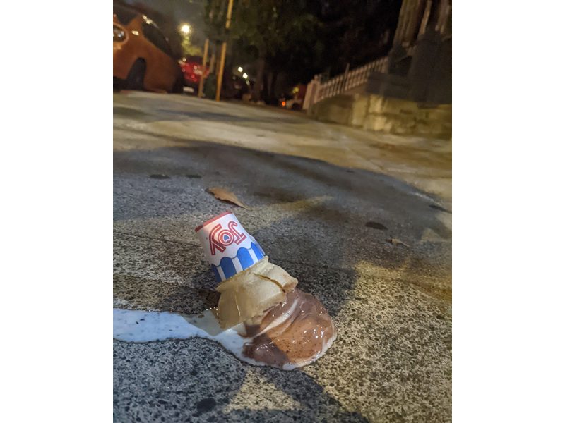 An ice cream cone on the sidewalk