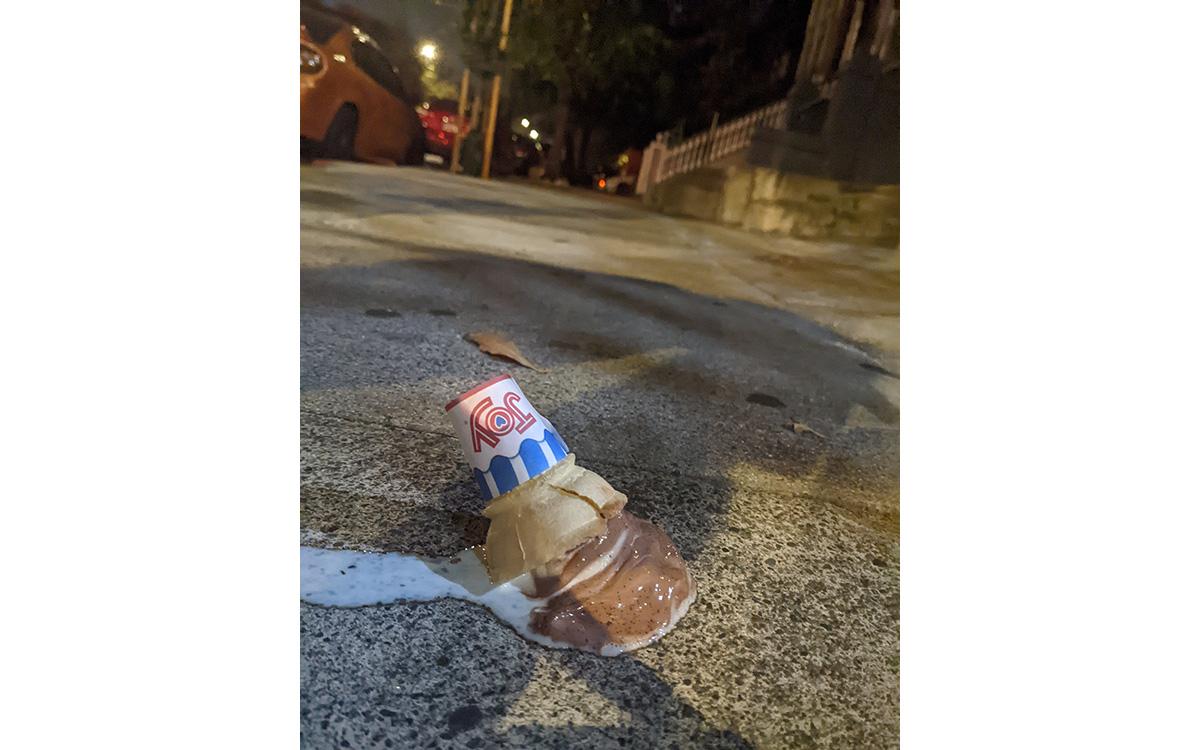 An ice cream cone on the sidewalk