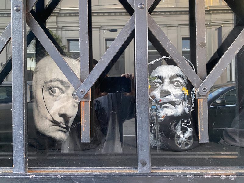 Two cutouts starring out from a barred window