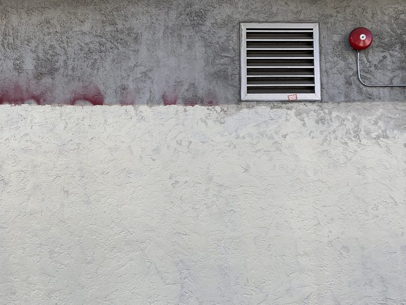 The edge of a building that meets the siidewalk