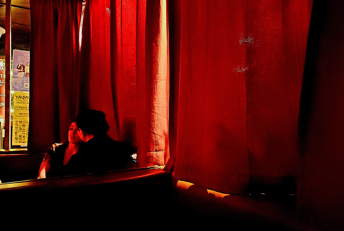 Two people in a dark bar.