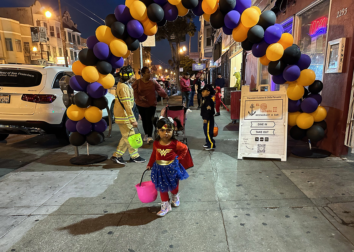 A young girl passing through a balloon arbor