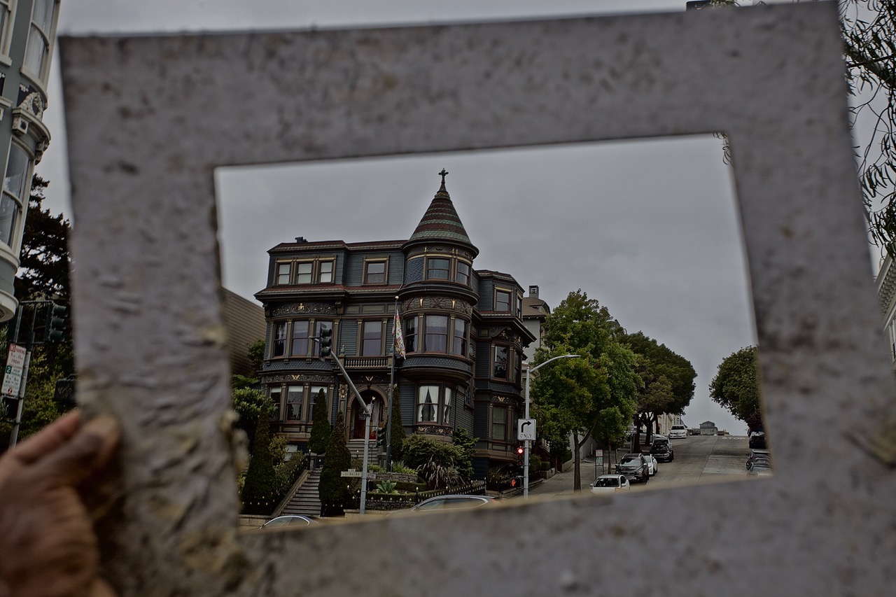A green victorian seen through a frame held by someone.