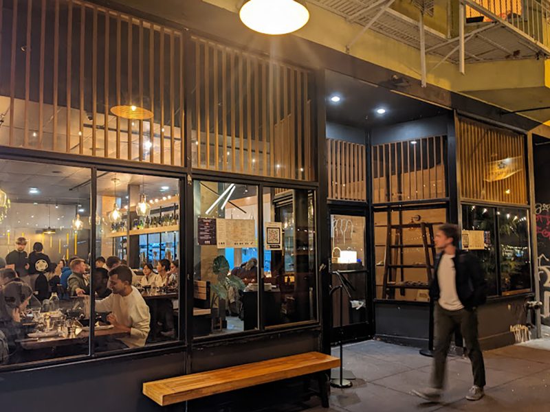 Exterior of a restaurant with a man walking by