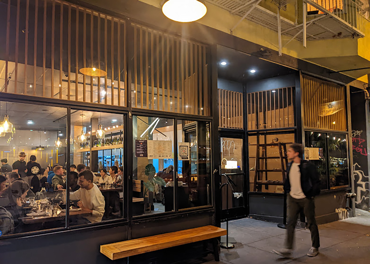 Exterior of a restaurant with a man walking by