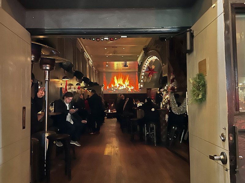 Looking through a big door at a fireplace.
