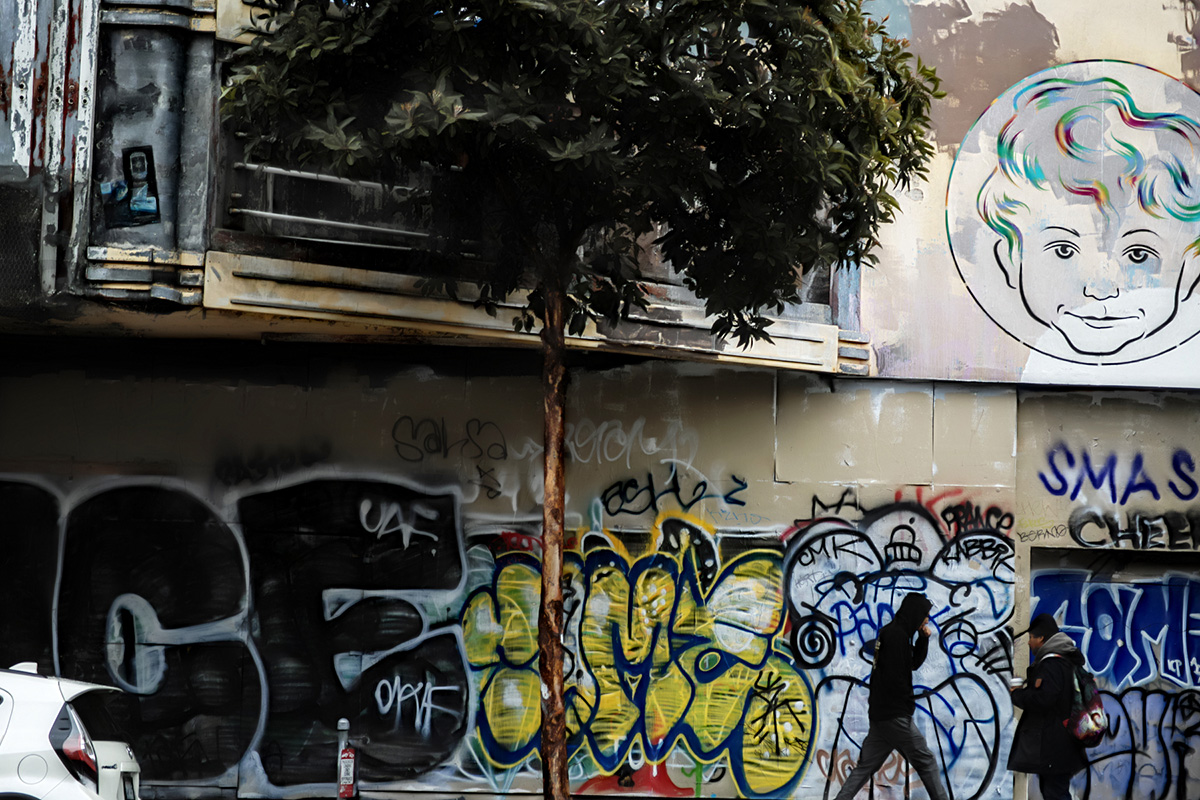 Graffiti and figures on an old cinema facade.
