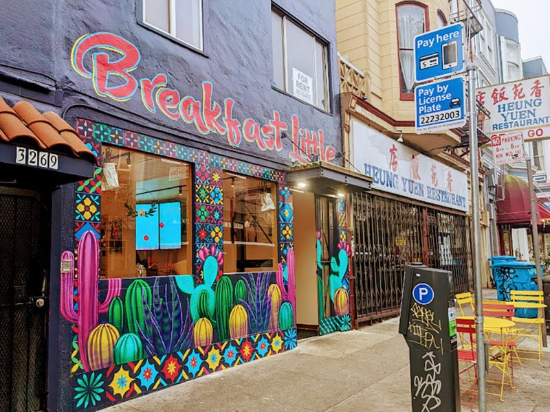 Exterior of a diner with a grey and colored mural.