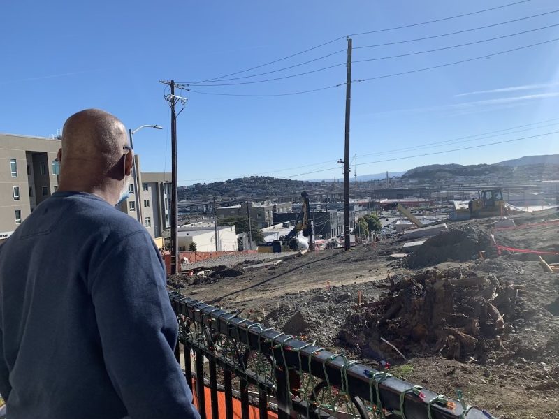 A community leader looks out at a construction site that some tenants fear may be making the kids sick.