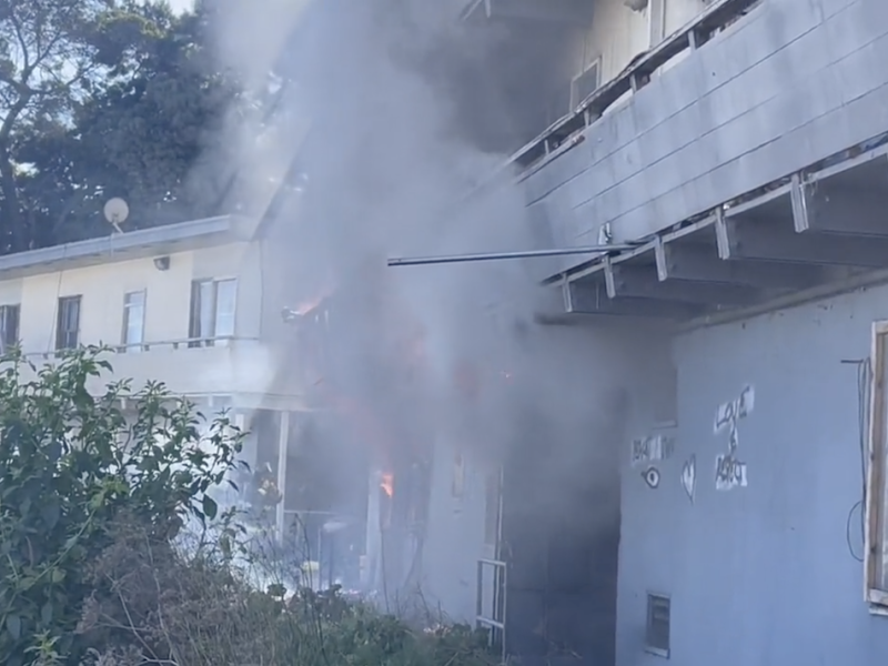 Smoke billows out of an apartment building
