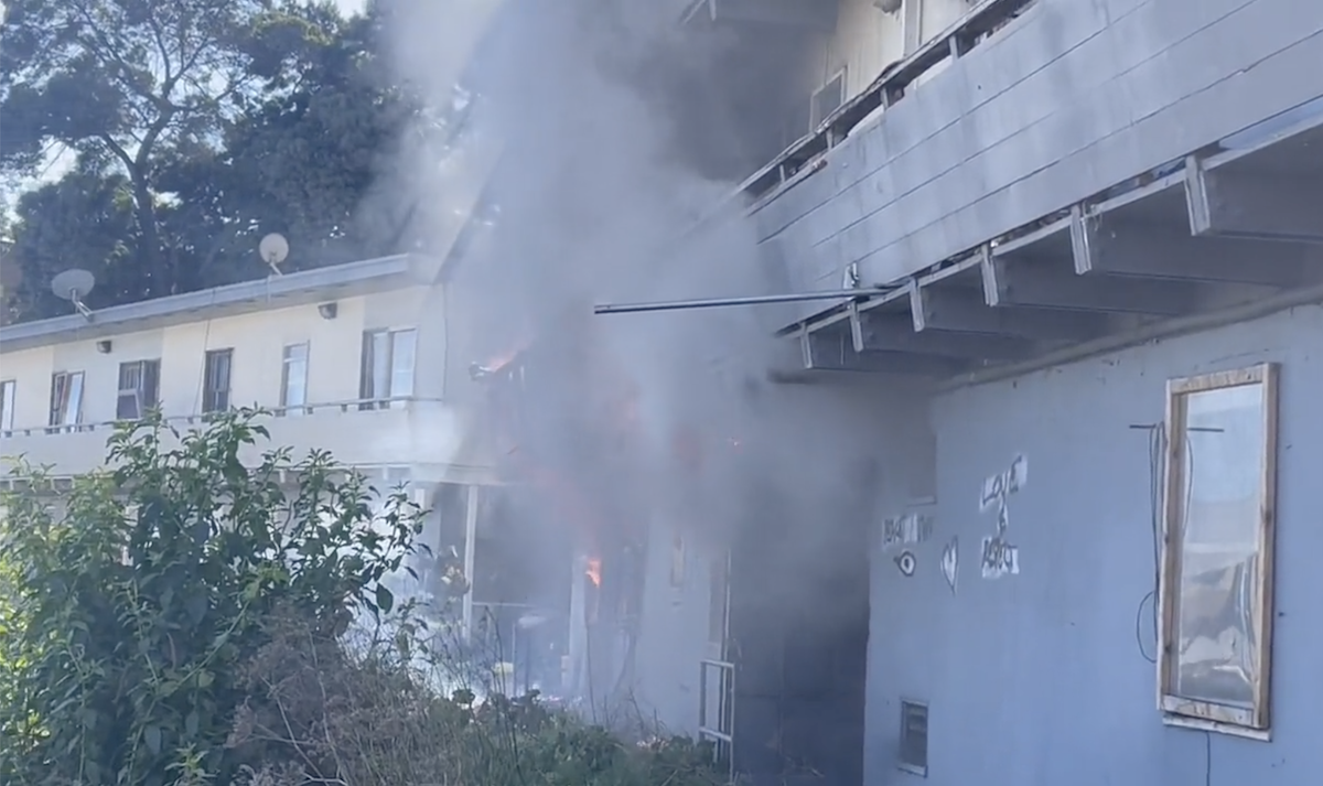 Smoke billows out of an apartment building