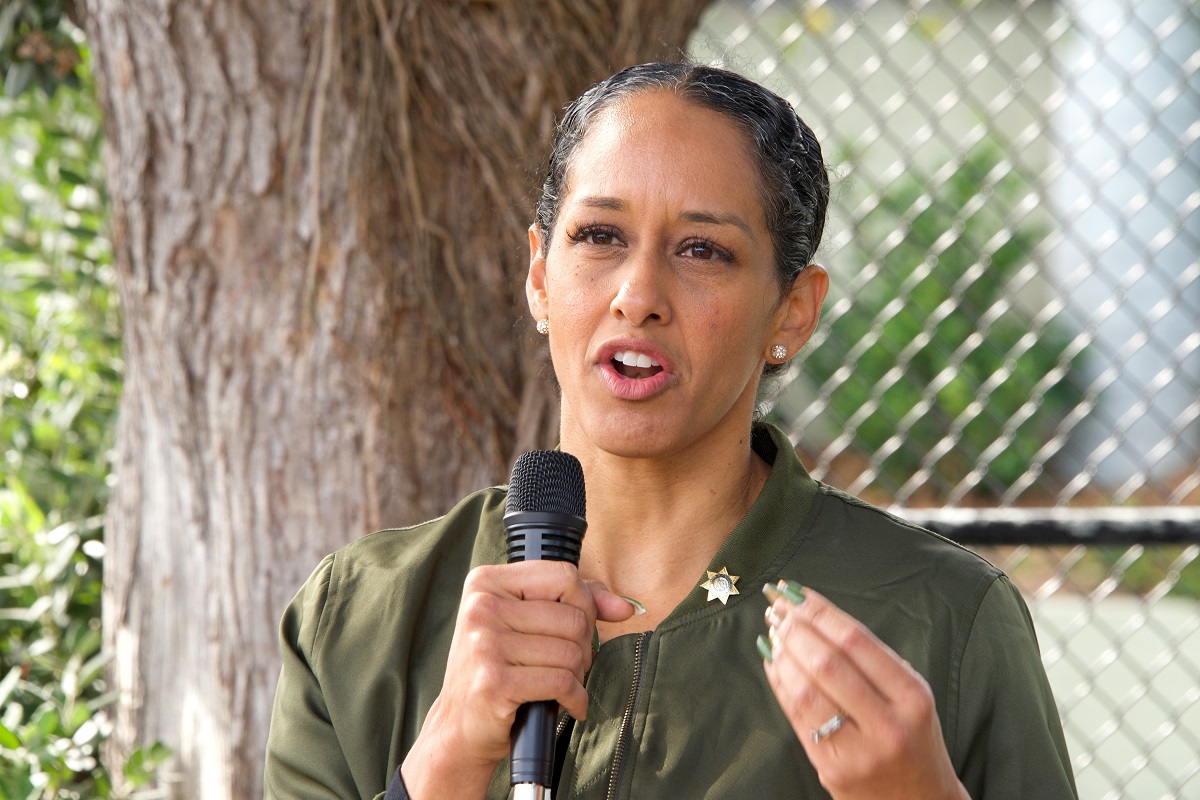 District Attorney Brooke Jenkins speaks into a microphone.