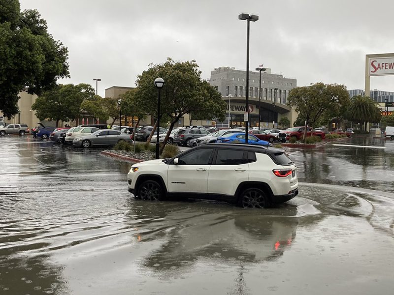 A car in lots of water at the Safeway parking lot.