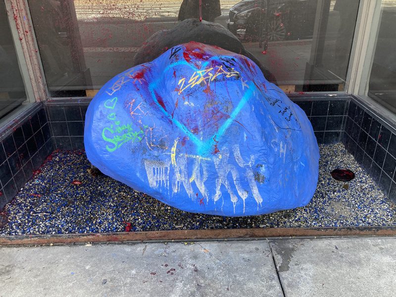 A large boulder, painted blue, in a doorway.