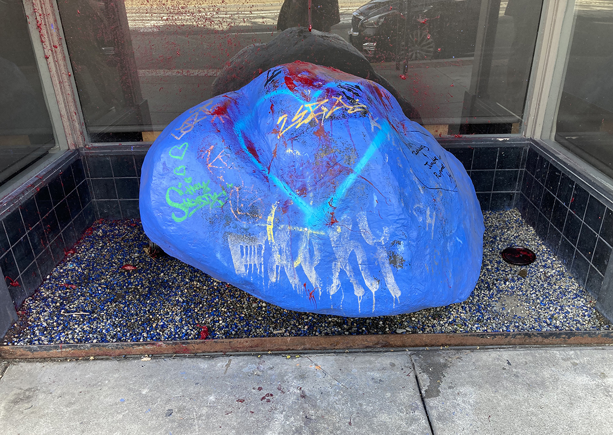 A large boulder, painted blue, in a doorway.