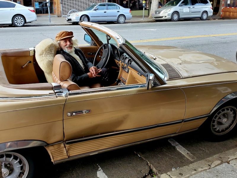 Man in gold convertible car