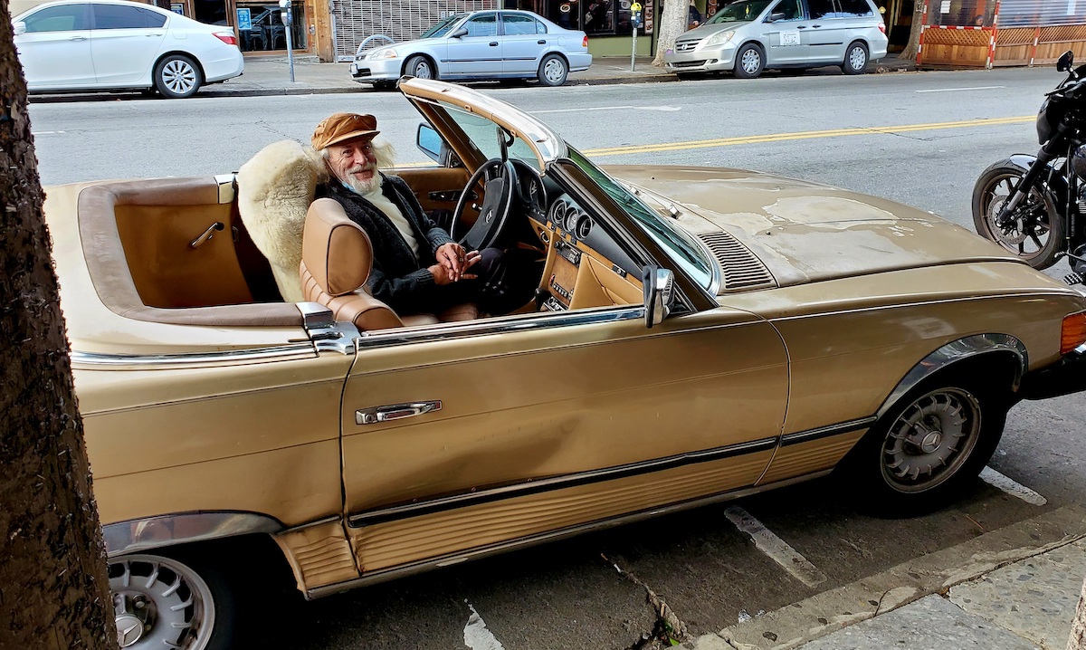 Man in gold convertible car