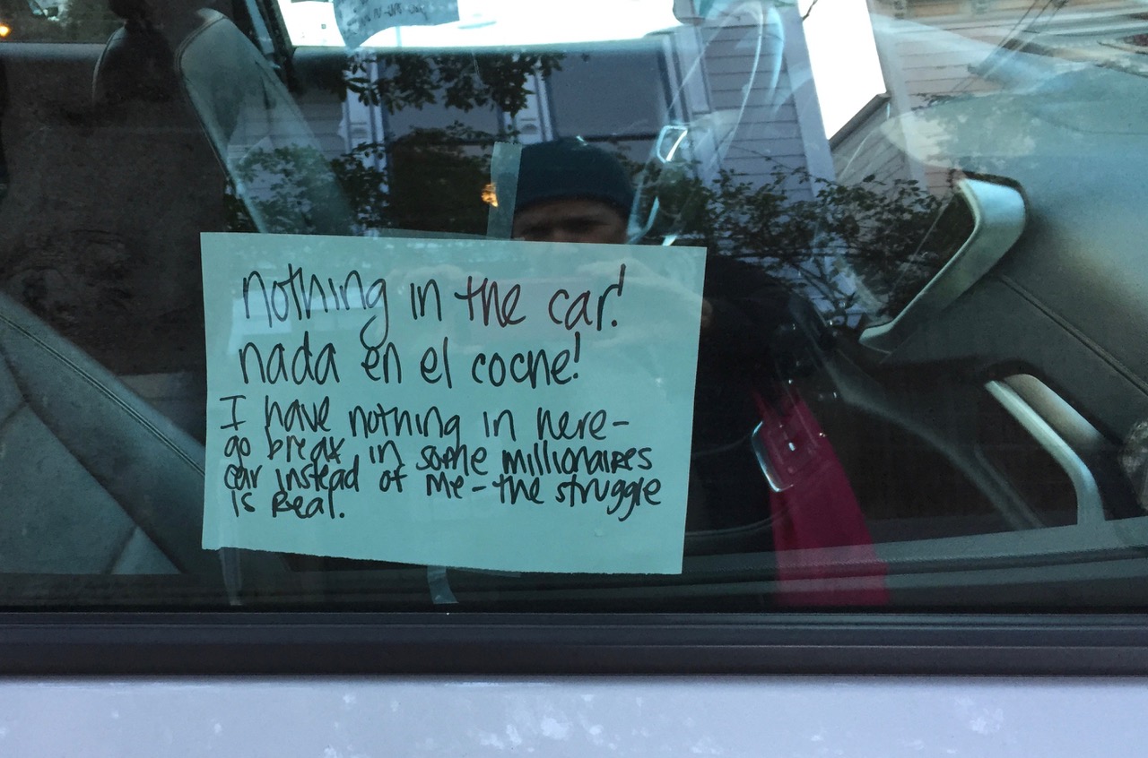 A sign on the car window telling people that there is nothing to steal.